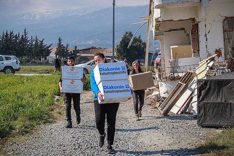 Bilge Menekşe von der Diakonie Katastrophenhilfe übergibt Hygieneboxen für Erdbebenopfer im Buyuk Dalyan Distrikt von Hatay. Projektpartner: STL-Support to Life (© Kerem Uzel/Diakonie Katastrophenhilfe)